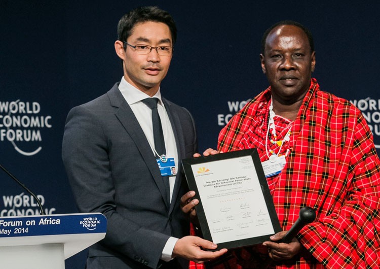 Martin Saning'o (right), receiving an award or certificate at the World Economic Forum.